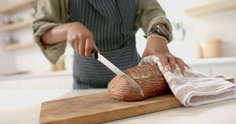African American Woman Slicing Artisan Bread in Modern Kitchen