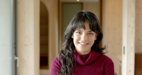 Smiling Hispanic Woman at Home in Cozy Ambience