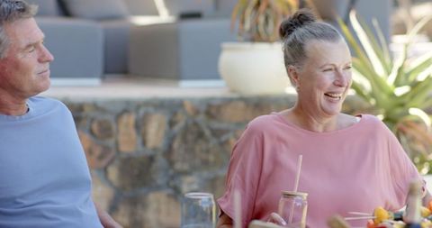 Happy mature couple enjoying drinks on tranquil patio