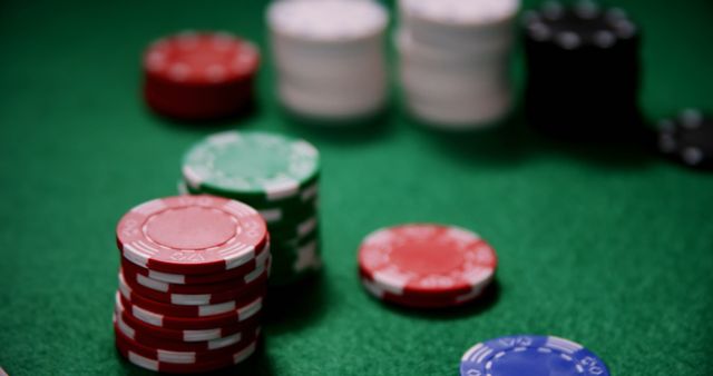 Poker chips in various colors arranged on a green felt table, indicating a game in progress. These can be used for content related to gambling, casinos, tabletop games, or competitive gaming events. Ideal for blogs on gambling strategies, casino advertising, or gaming websites.