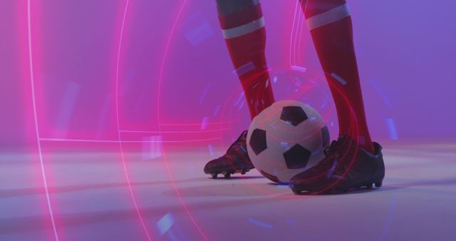 Showing legs of a soccer player in red socks and black cleats, poised to kick a soccer ball, surrounded by an abstract neon light design. Perfect for sports promotion, modern advertisements, athletic events, or articles about advancing sports technology. Highlights action and futuristic themes in sports.