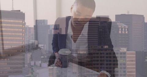 Executive reviewing documents with coffee in high-rise office overlooking city skyline