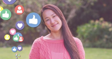 Smiling asian woman with social media interaction icons