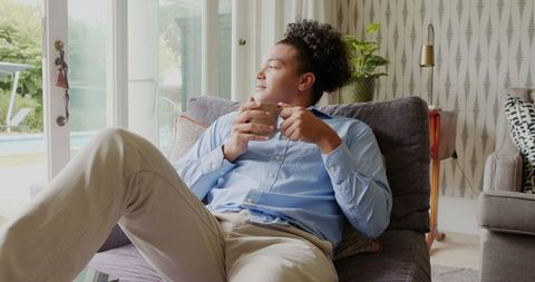 Man Relaxing with Coffee Looking Out Sliding Glass Door
