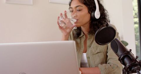 Woman Recording Podcast in Home Office with Microphone and Laptop
