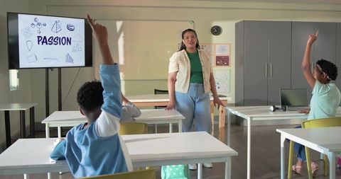 African-American teacher leading engaged students raising hands with PASSION presentation in classro