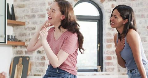 Excited women celebrating engagement in bright kitchen