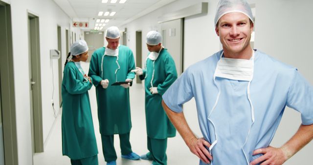 Confident Male Surgeon with Team Collaborating in Hospital Corridor - Download Free Stock Images Pikwizard.com