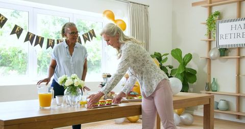 Senior Friends Celebrating Retirement With Food and Drinks Indoors