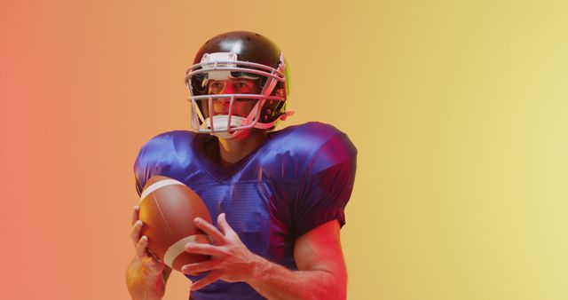 Football player standing with ball in both hands, wearing helmet and blue jersey. Orange and yellow background enhances energetic atmosphere. Ideal for sports events, fitness campaigns, athletic training promotions, motivational posters.