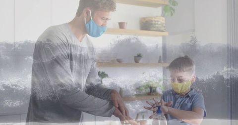 Father and Son Wearing Masks Sanitizing Hands in Modern Kitchen