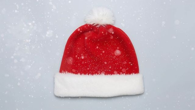 Classic Red Santa Hat with White Faux-Fur Brim and Fluffy Pompom, Falling Snow on Pale Gray