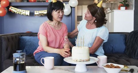 Senior Friends Celebrating Birthday with Cake and Gifts at Home
