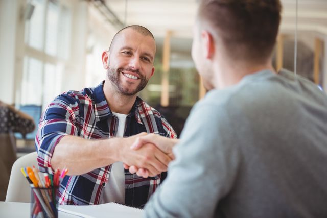Young business people shaking hands in creative office
