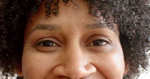 Close-Up of Woman with Curly Hair Smiling Warmly