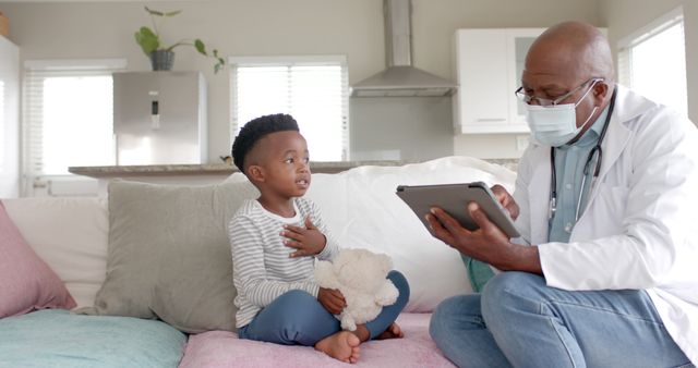 Doctor Using Tablet During Home Visit with Young Child - Download Free Stock Images Pikwizard.com