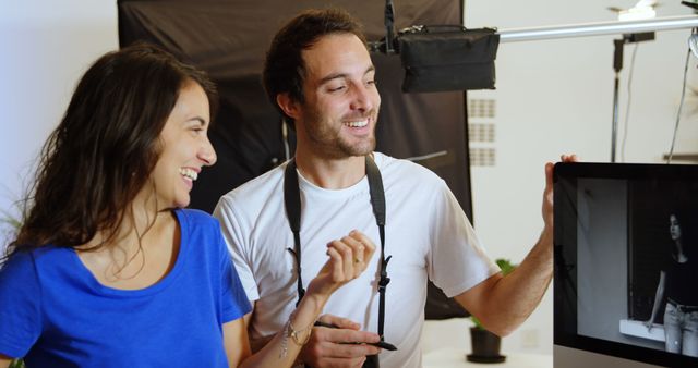 Cheerful Photographers Reviewing Shots in Modern Studio - Download Free Stock Images Pikwizard.com