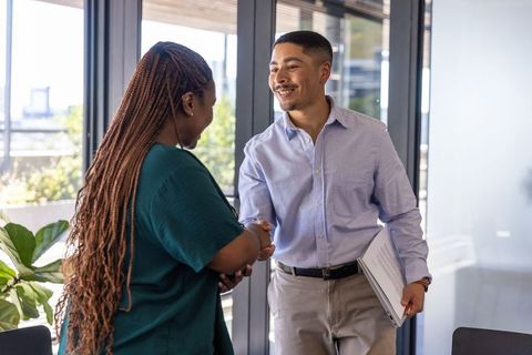 Diverse Colleagues Greeting in Modern Office Environment