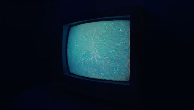 Vintage crt tv with blue static in dark room
