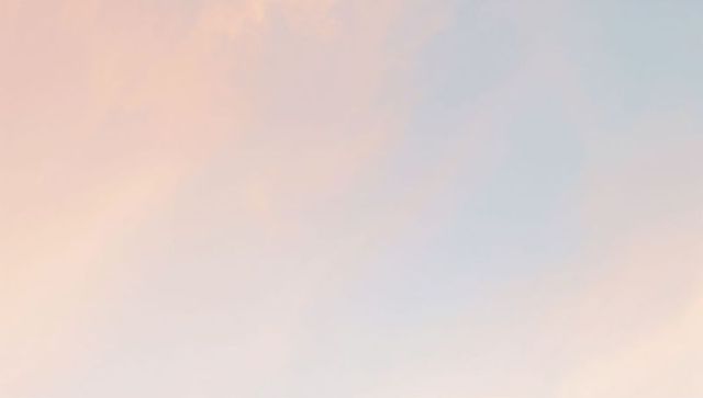 Pastel sunrise gradient sky with wispy clouds, soft peach to pale blue minimal background