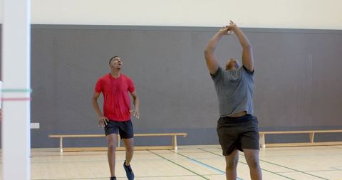 African american athletes jumping and running on indoor gym hardwood court for training