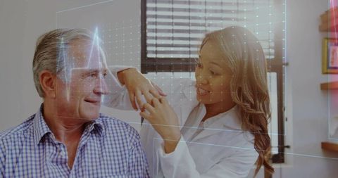 Female clinician adjusting senior man's ring during holographic facial scan