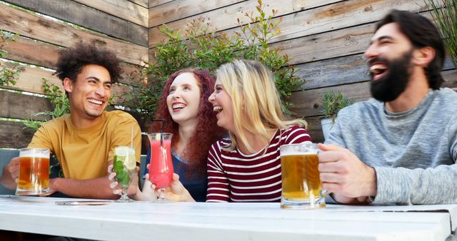 Young adults savor friendship and fun over drinks outdoors, epitomizing social joy. - Download Free Stock Photos Pikwizard.com