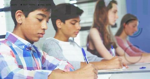 Teenagers writing notes in classroom focusing on study, concentration and academic work