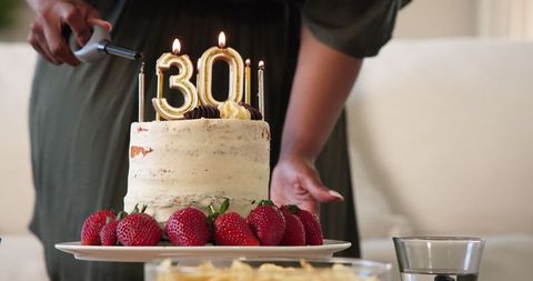 Celebration with Strawberry-Topped Birthday Cake and Golden Candles