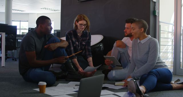 Diverse Team Collaborating on Project Sitting on Floor in Modern Office - Download Free Stock Images Pikwizard.com