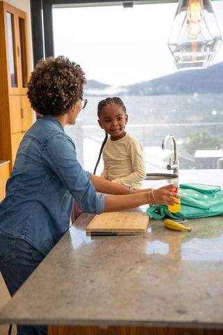 Parent and child packing healthy snack in kitchen
