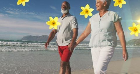 Senior couple enjoying beach walk amidst falling flowers