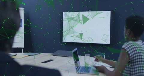 Woman Taking Notes During Tech Presentation with Laptop and Network Visualization