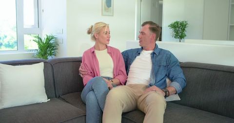 African american couple sitting close on gray sofa sharing relaxed conversation and warmth