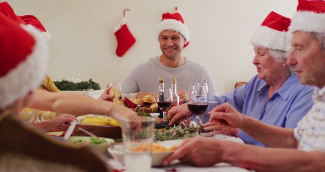 Multi-generational family celebrating Christmas dinner in festive hats - Download Free Stock Images Pikwizard.com