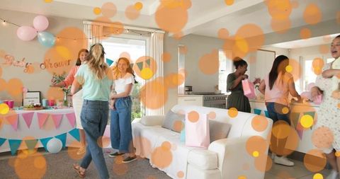 Joyful baby shower gathering with friends celebrating in pastel-decorated living room