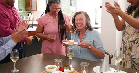 Diverse Senior Friends Celebrating Birthday with Cupcake Candle