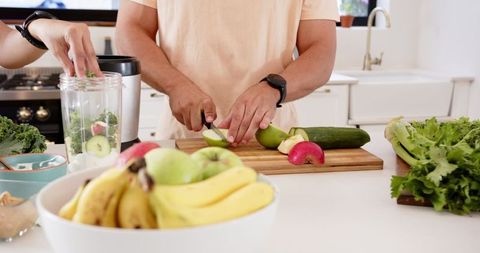Couple Making Healthy Green Smoothie in Bright Kitchen