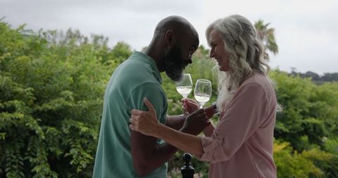 Seniors Celebrating Together on Balcony with Wine and Nature