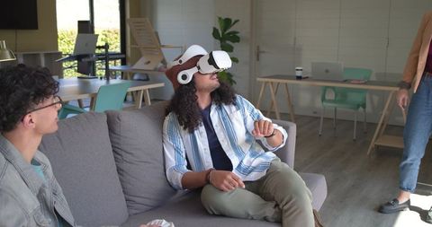 African American Man Wearing White VR Headset in Modern Coworking Lounge Collaborating