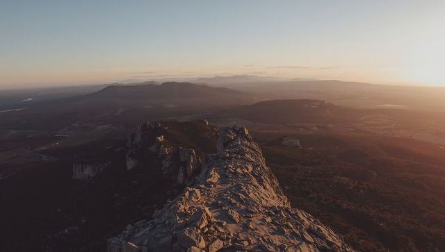 Sunrise Lighting Jagged Mountain Ridge Leading Into Expansive Valley and Plateaus