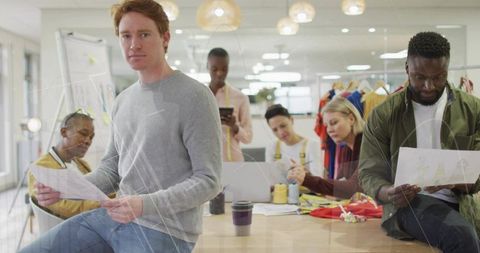 Creative team reviewing fashion sketches and fabric swatches at collaborative design table