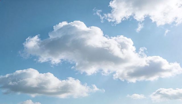Drifting Cumulus Clouds Floating Across Bright Blue Sky Sunlit Daytime Atmosphere