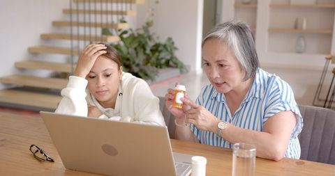 Grandmother Explaining Medication to Granddaughter Online at Home