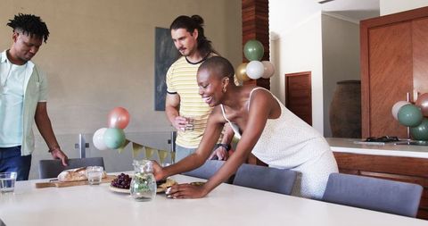 Friends celebrating with snacks around dining table