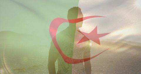 Standing black man on shoreline with algerian flag overlay, sun flare and silhouette