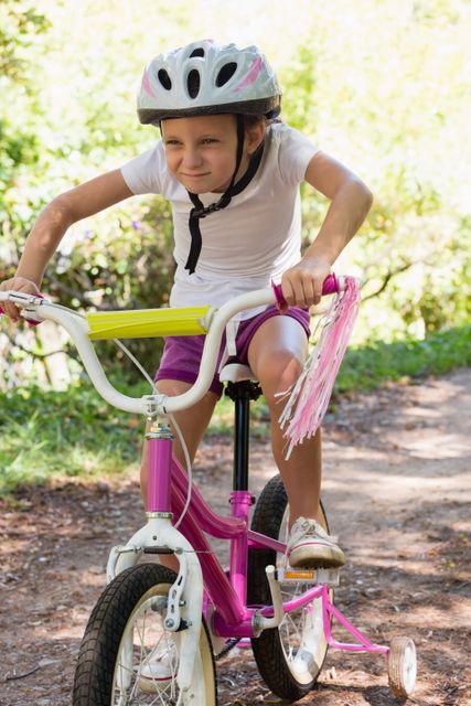 Smiling girl cycling in the forest on a sunny day