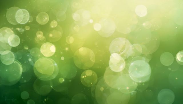Green bokeh light background featuring glowing orbs, soft halo, and sunlit gradient