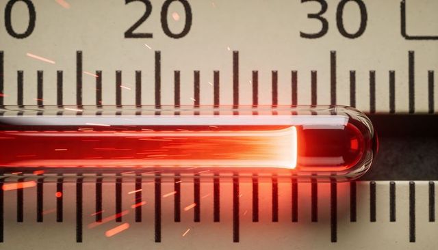 Glowing red glass capillary tube on measurement scale with sparks, closeup calibration