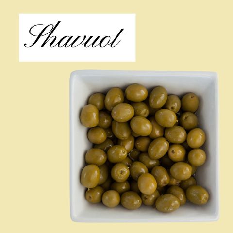 Green olives for shavuot celebration on yellow background